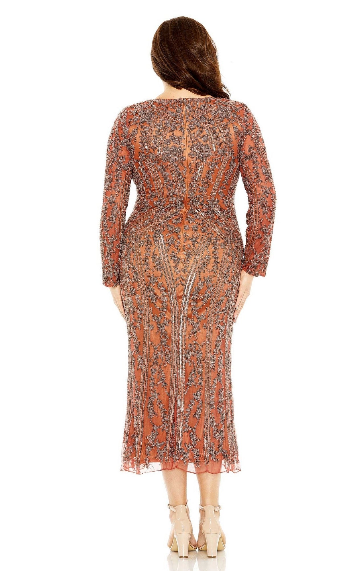 A woman in the Plus Size Wedding Guest Dress 5938 by Mac Duggal, featuring long sleeves and intricate beadwork, stands facing away in nude heels.
